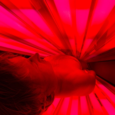 Person In A Red Light Therapy Bed